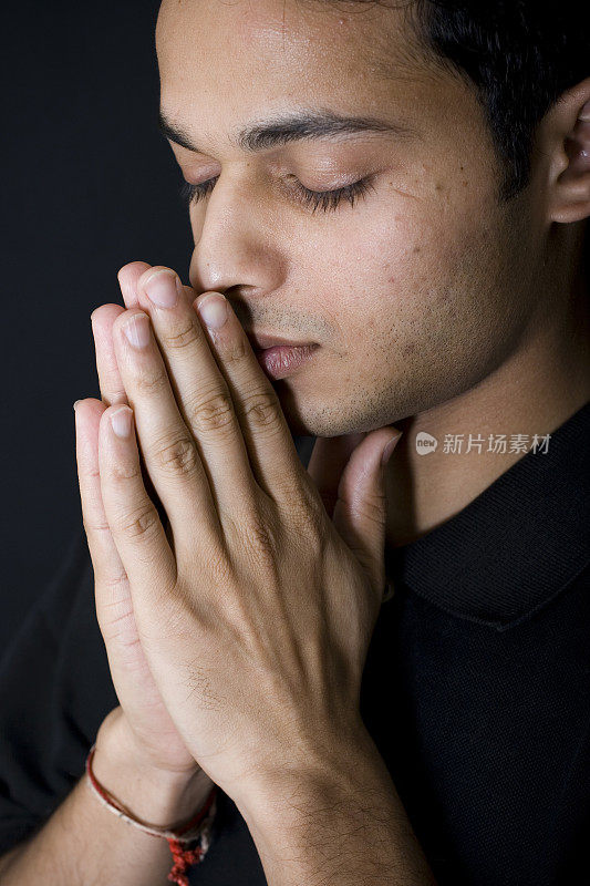 垂直黑色肖像的一个印度青年男子男性祈祷