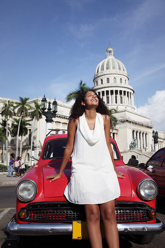一位年轻的古巴妇女站在古巴哈瓦那的卡皮托里奥前