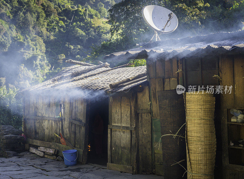 烟雾从喜马拉雅山下的卫星天线下的简单的家庭流尼泊尔