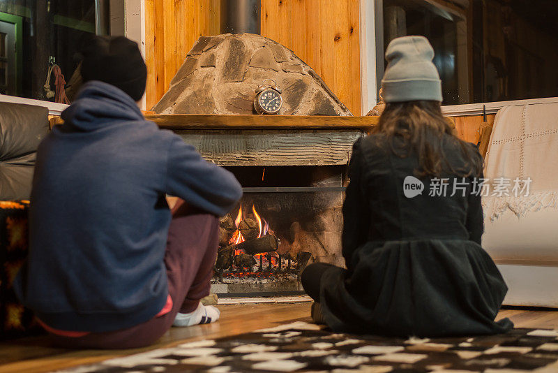 男孩和女孩在壁炉前享受山的寒冷