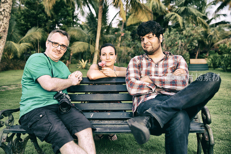 3个朋友在长椅上休息。喀拉拉邦。印度