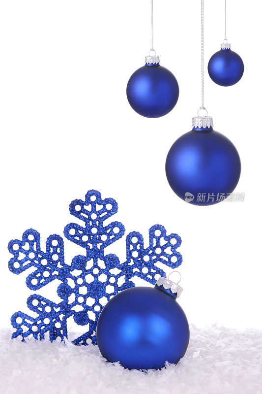 蓝色的节日装饰品和雪花在雪中