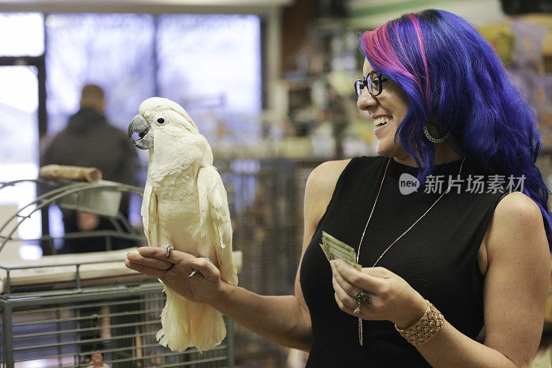 一个女人在宠物店买鹦鹉