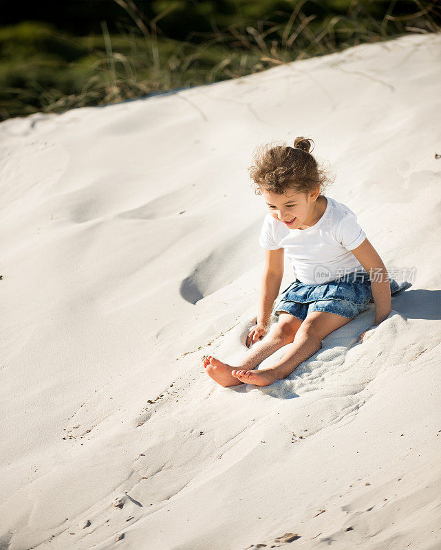 可爱的小女孩在沙滩上玩耍