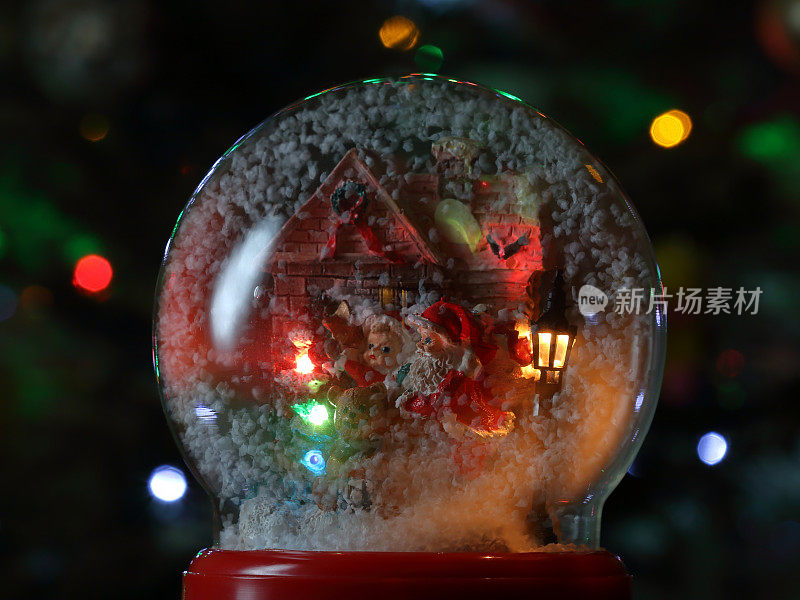 有圣诞老人和灯笼的玻璃雪花球。圣诞玩具