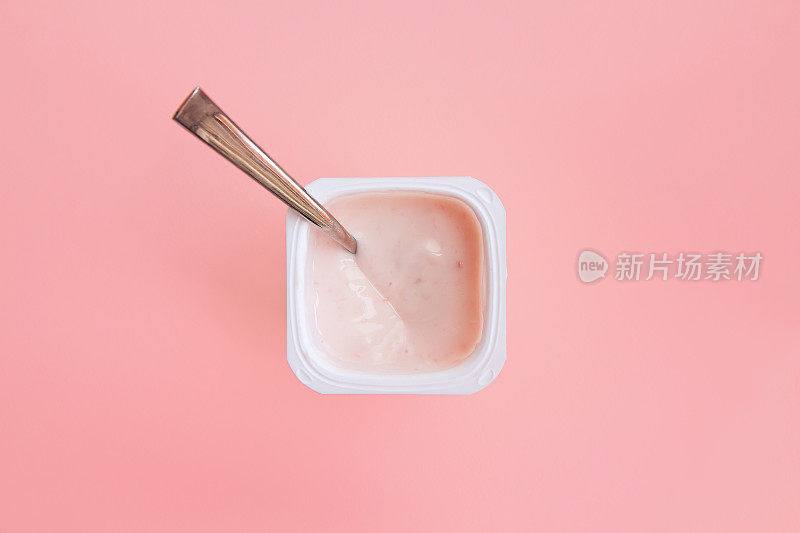 草莓粉酸奶，里面有勺子。平的。