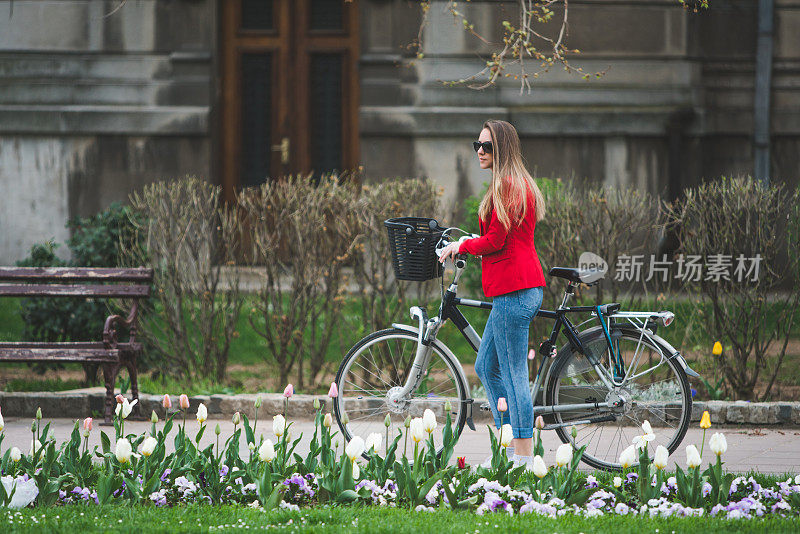 年轻女子骑着自行车在城市里