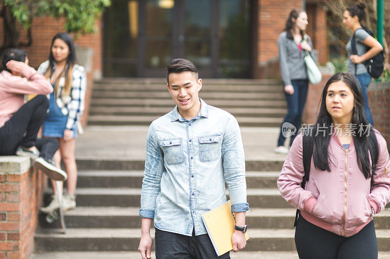 学生们在大学课间在大楼外面的楼梯上闲逛