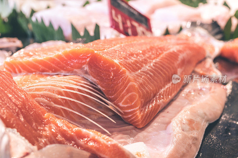 仔细观察生三文鱼片的肉质。印度尼西亚巴厘岛当地食品市场上的生鲑鱼和大西洋鱼