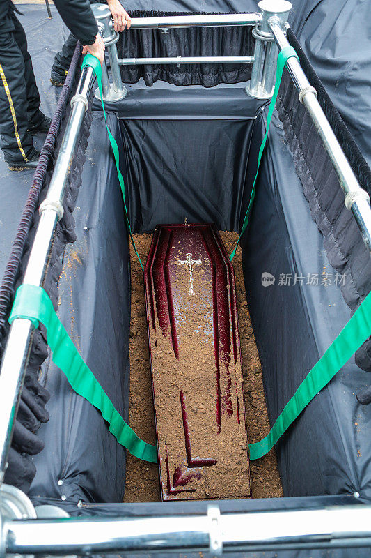 棺材在坟墓。埋在坟墓里的棺材上撒了土。传统的葬礼