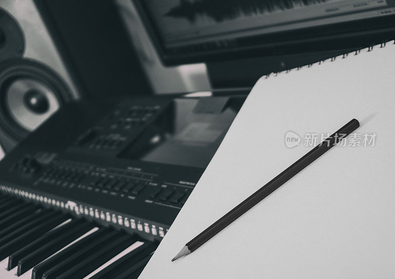 钢琴键盘，笔和表。作曲的概念。黑色和白色。