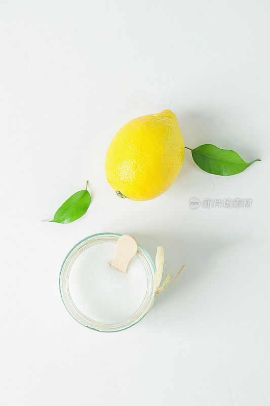 成熟的黄色柠檬绿色柑橘叶糖在玻璃罐。白色混凝土石材桌面上的磨砂成分。有机化妆品阿育吠陀健康生活理念。本空间