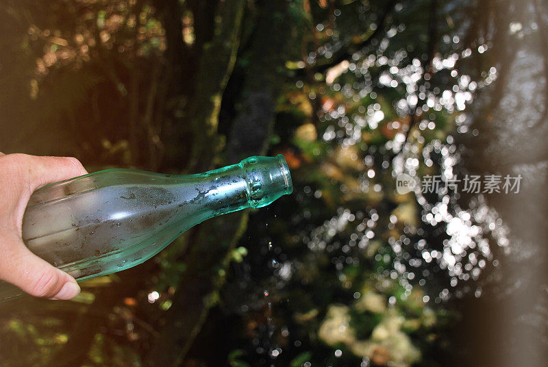 淡水水概念;玻璃水瓶与河流背景