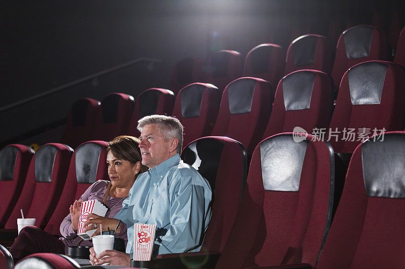 成熟的多民族夫妇独自在电影院