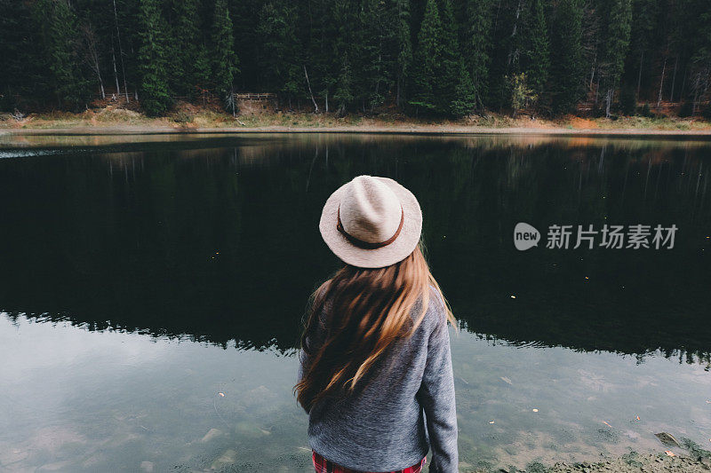 戴着帽子的女人在山中湖中感受自由