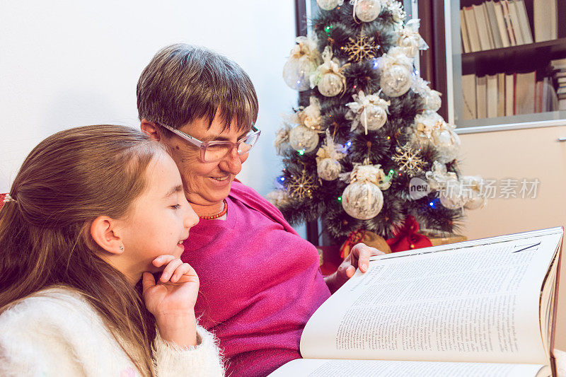 圣诞节期间，奶奶看书，孙女玩得很开心