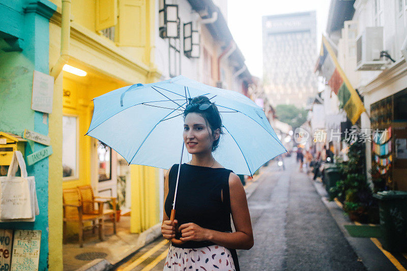 旅女在雨中探索新加坡的小巷子