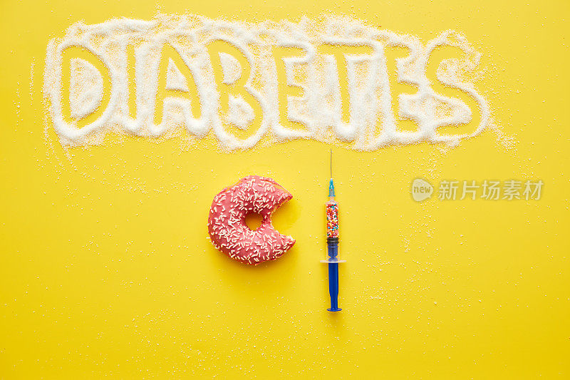糖尿病概念的原因:糖尿病字高角度看砂糖，吃了一半的甜甜圈和注射器充满糖屑