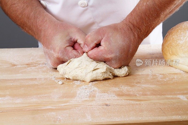 面包师揉面团的手的特写图像