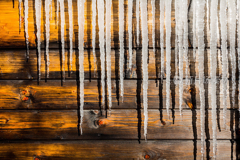 潮湿的木墙上融化的冰柱
