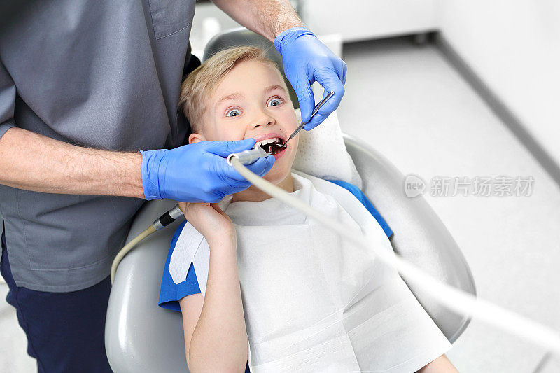害怕看牙医。坐在牙科椅上受惊的孩子。