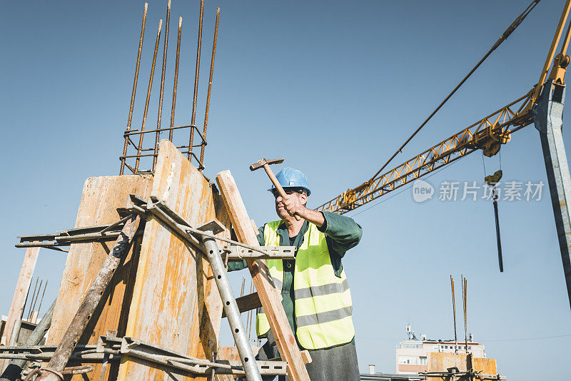 建筑工人正在建筑工地上和铁锤一起工作