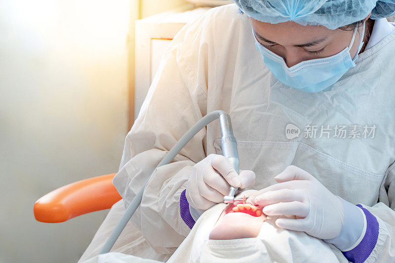 女亚洲牙医在牙科诊所使用仪器治疗和钻孔病人的牙齿。牙科程序和医疗。