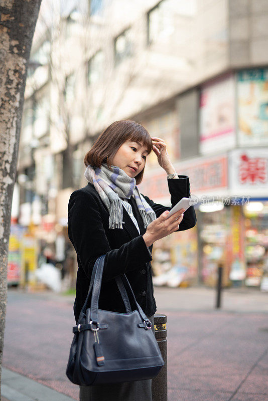 女商人在街上看智能手机