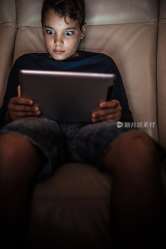 十几岁的男孩在晚上使用电子桌子