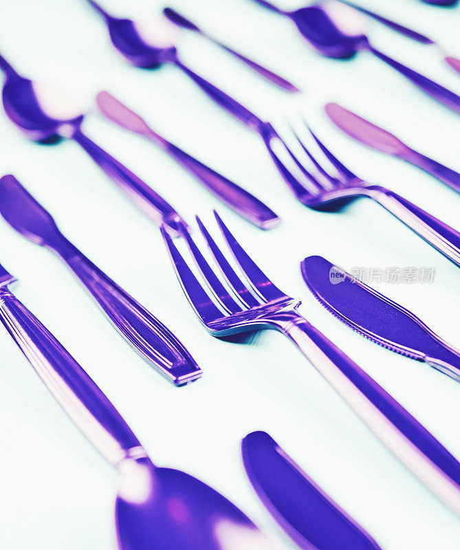 平铺背景与紫色的叉，刀和勺子