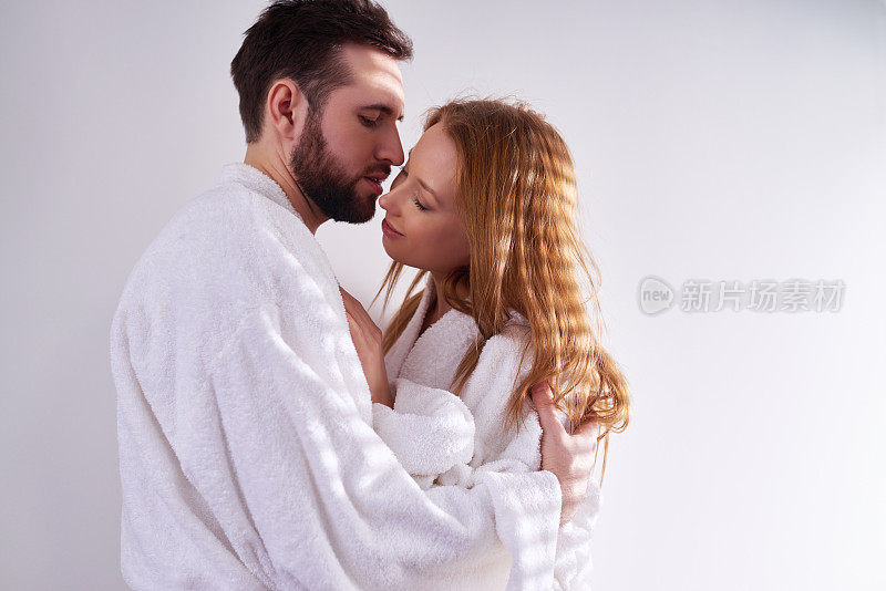 爱抚性感的情侣在白色浴衣