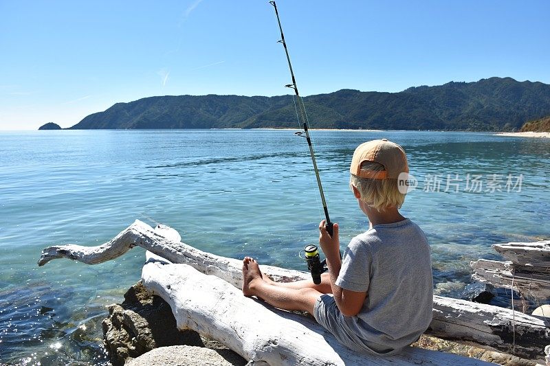 在海边钓鱼的小男孩