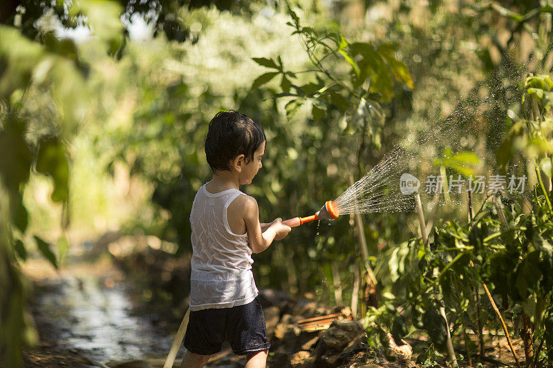 幼童在夏天在户外玩水管