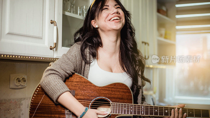 厨房里拿着吉他的女人