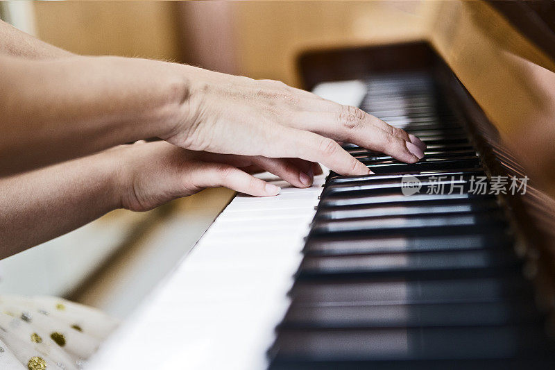 一个老师的手超过了孩子的学习她的普拉特钢琴