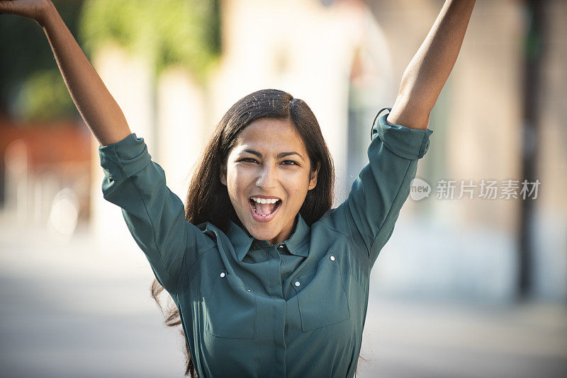 成功后兴奋的女商人举起双臂