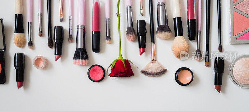 化妆理念:专业的化妆工具及配件。口红、睫毛膏、指甲油、眼影、粉、睫毛膏和粉底。前视图。