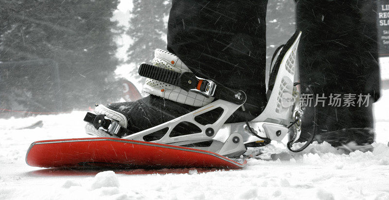 一个滑雪者把他们的靴子的脚在一个雪天，阴天在科罗拉多州博尔德附近的埃尔多拉滑雪度假村滑雪板绑定