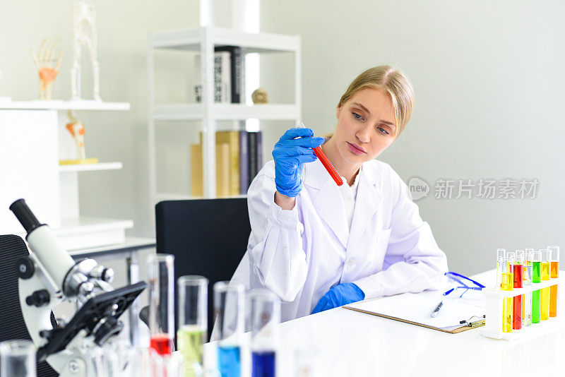 年轻的女科学家做一些研究工作，在现代实验室进行实验和显微镜-科学家在实验室生物化学、遗传学、法医学、微生物学和试管女医生