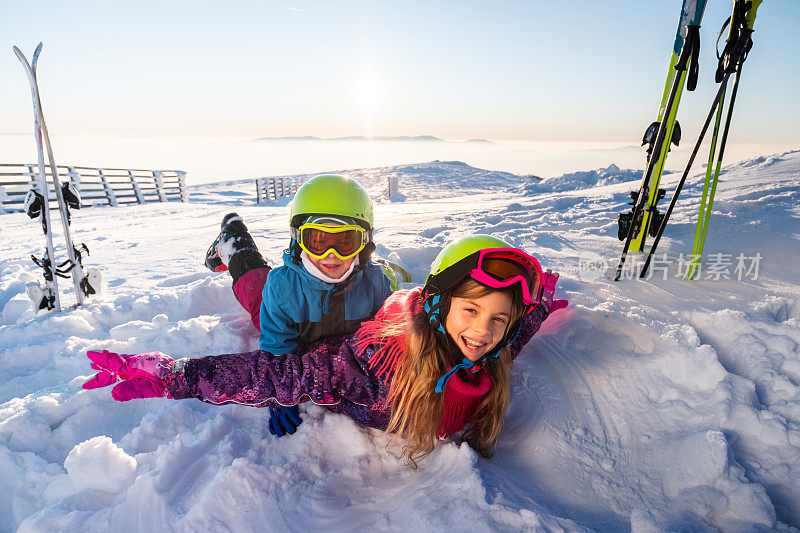 孩子们高举双手在雪地里玩耍