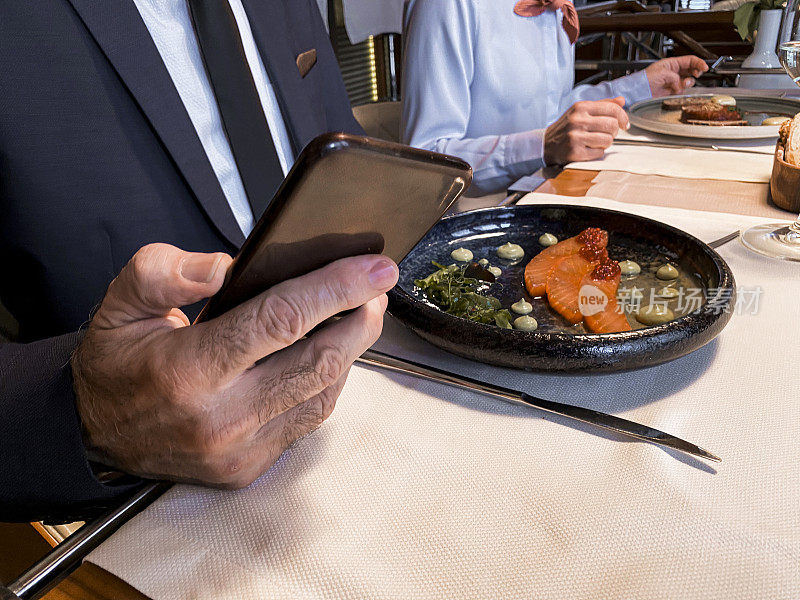 在餐厅吃午餐时使用智能手机
