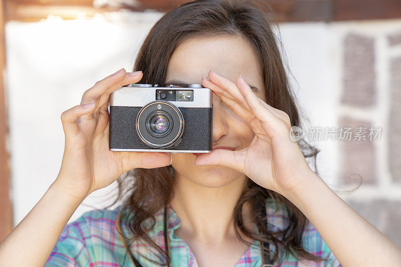 一个摄影师用相机遮住她的脸的肖像。旅游旅游相机摄影概念旅游。