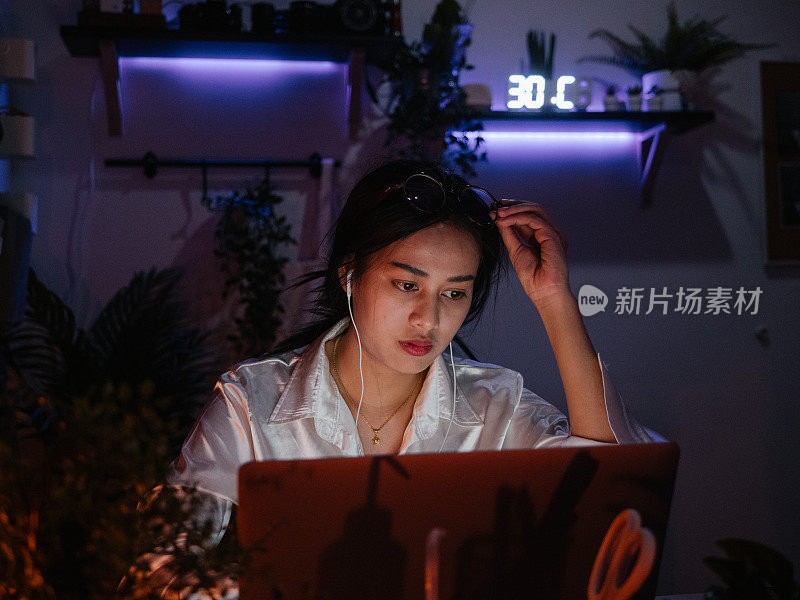 女员工在家用笔记本电脑努力工作到深夜。商务人员加班工作。