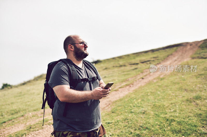 徒步旅行者在登山时查看智能手机地图