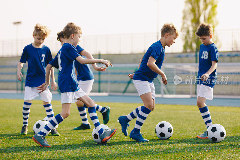在学校操场上练习足球的男孩。10岁的孩子在足球训练班。小学学龄儿童体育课
