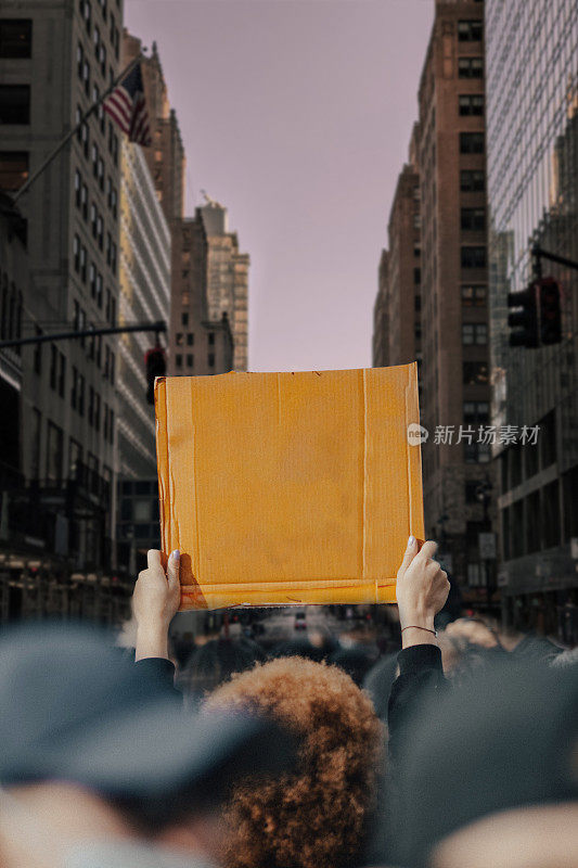 在城市街道上，一名男子举着标语抗议