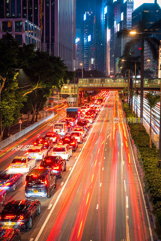 霓虹夜路，高速公路，高速交通穿过摩天大楼的城市景观香港