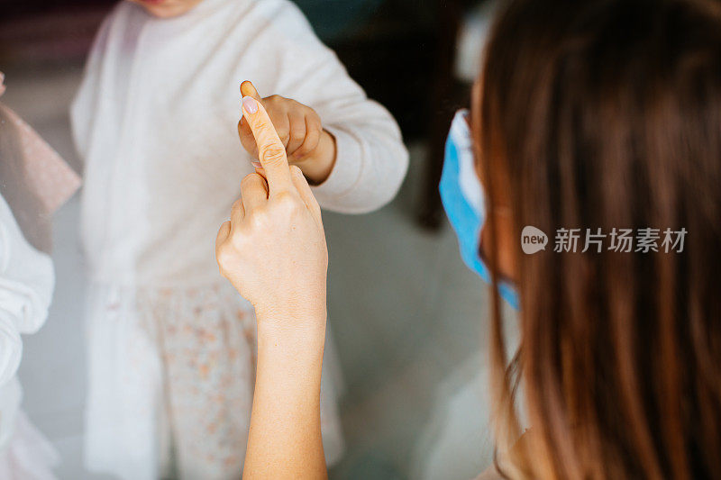 女儿探望被隔离的母亲，防止通过窗户感染冠状病毒