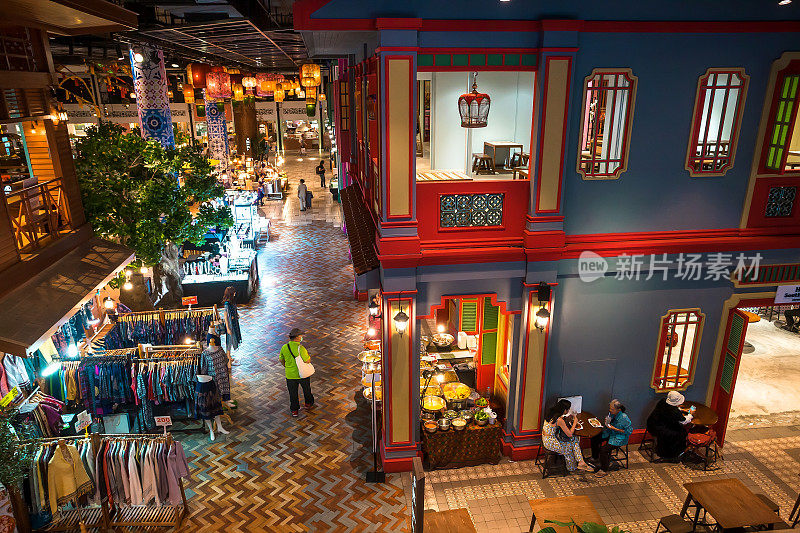 人们在巨大的购物中心里购物和吃午餐，这里有着传统的亚洲小镇风格，有商店和咖啡馆