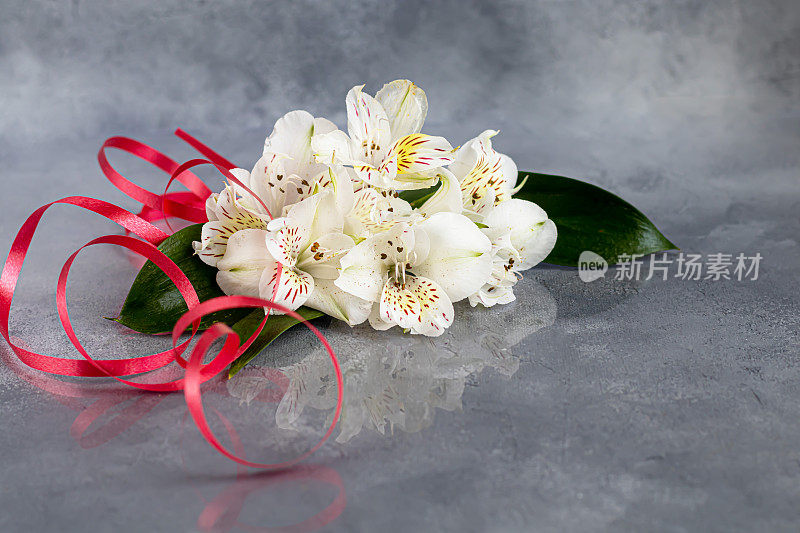 在用丝带装饰的浅色背景上，放着一束野生兰花。母亲节、妇女节、情人节或生日。禁令。